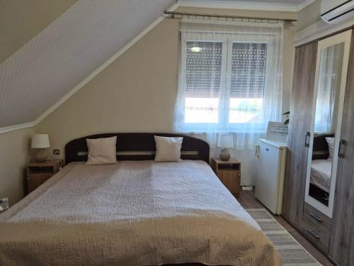 a bedroom with a large bed and a window at Horgász-Vadász Vendégház in Egyek