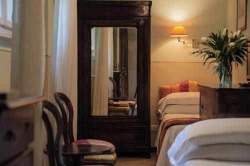 a hotel room with two beds and a mirror at Hotel Villa Liana in Florence