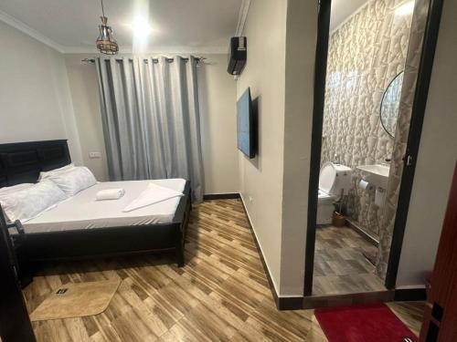 a small bedroom with a bed and a mirror at Gekamo Suites in Dar es Salaam