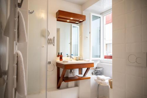 a bathroom with a sink and a mirror at Hotel Les Almadies - Coeur de Ville in Saint-Jean-de-Luz