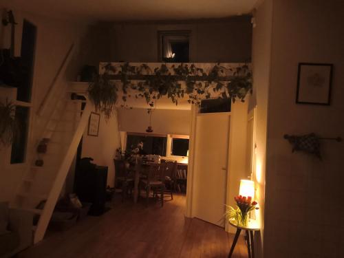 a living room with a staircase and a dining room at Chalet with sauna close to the sea in Noordwijk aan Zee