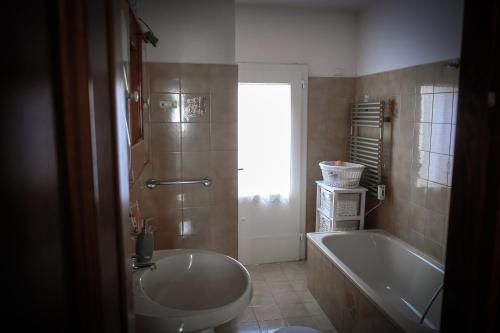 a bathroom with a tub and a sink and a bath tub at La Pausetta in Foligno