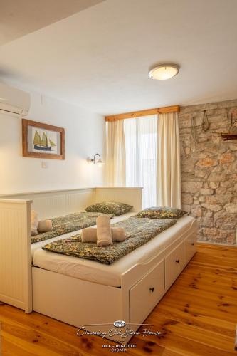 a large bed in a room with a stone wall at Charming old stone house in Sali