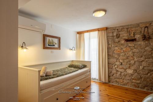 a room with a bench in a room with a stone wall at Charming old stone house in Sali