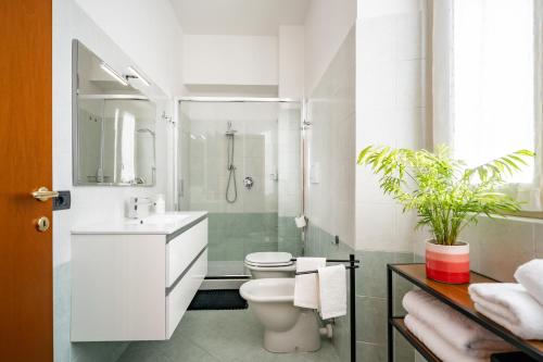 a white bathroom with a toilet and a sink at Japo House - Like at your house in Pusiano