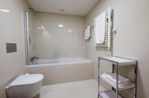 a bathroom with a tub and a toilet and a sink at Home At Porto - Aliados Apartments in Porto