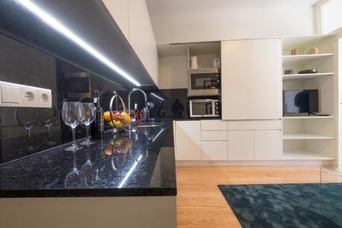 uma cozinha com copos de vinho num balcão em Home At Porto - Aliados Apartments em Porto