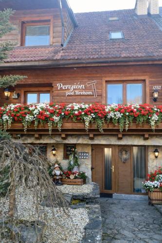 a building with flowers on the side of it at Penzion pod Brehom in Terchová