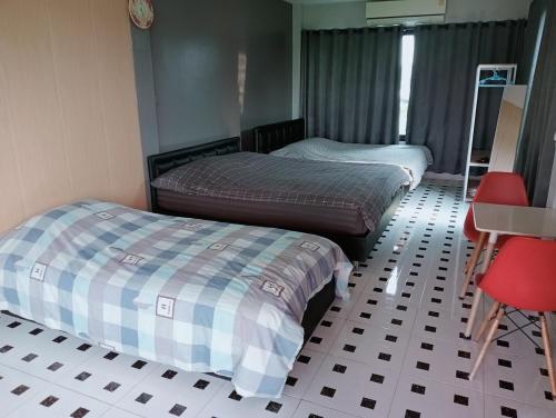 a room with two beds and a table and a desk at ฮิมแกนแฟมิลี่เฮ้าส์ in Ban Pong (2)