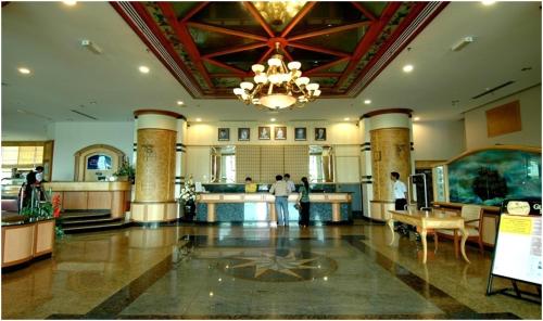 un vestíbulo con una lámpara de araña y gente en un edificio en The Paramount Hotel Sibu, en Sibu