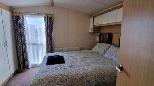 a small bedroom with a bed and a window at Oystercatcher Hide, Chruch Farm in Pagham