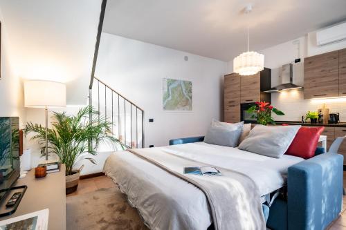 a bedroom with a large bed with a blue chair at Japo House - Like at your house in Pusiano