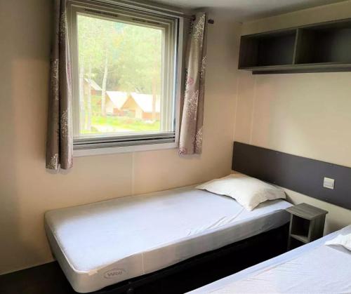 a small bedroom with a bed and a window at Cottage PARKS OLVA in Sartène