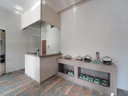 a kitchen with a counter with pots and pans at Palette Hotel Orient Greenz by CheckIn, Pench in Khawāsa