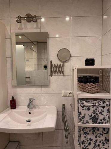 a white bathroom with a sink and a mirror at Ferienwohnung BungertOase in Saarburg
