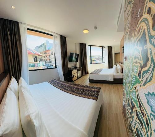 a hotel room with a bed and a large window at Sri Gaya Hotel in Kota Kinabalu