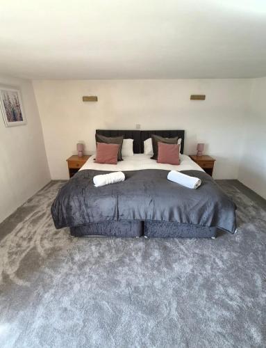 a bedroom with a large bed with two pillows at Dean Linhay in Lynton