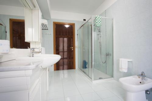 a white bathroom with a shower and a sink at Hotel San Marco in Rionero in Vulture