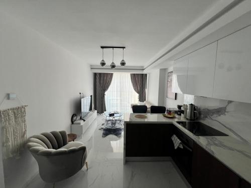 a white kitchen with a chair and a table at Grand Saphire Resort c blok in Aradhippou