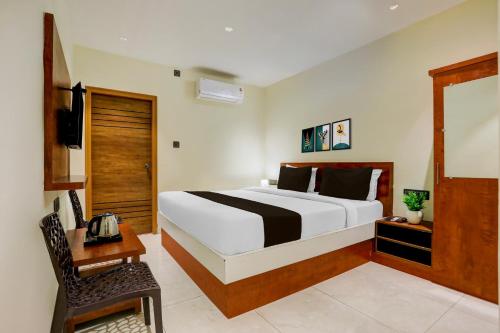 a bedroom with a large bed and a chair at Super Hotel O Ananthpur Formerly TR Residency in Anantapur