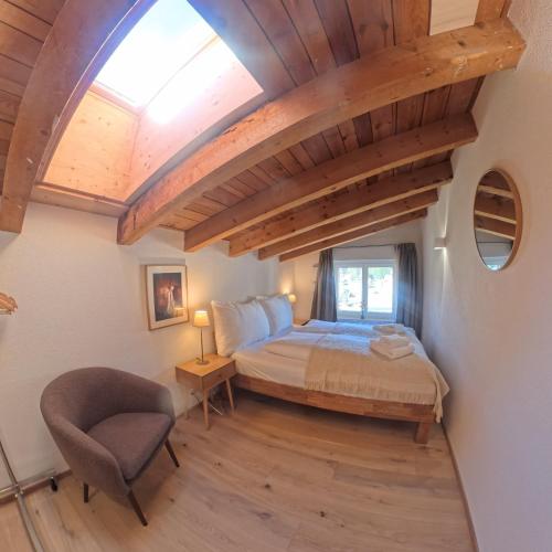 a bedroom with a bed and a chair at Apartment with mountain view in Lenzerheide