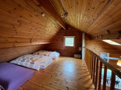 a room with a bed in a wooden cabin at Family Cottage Pokhara in Yamanakako