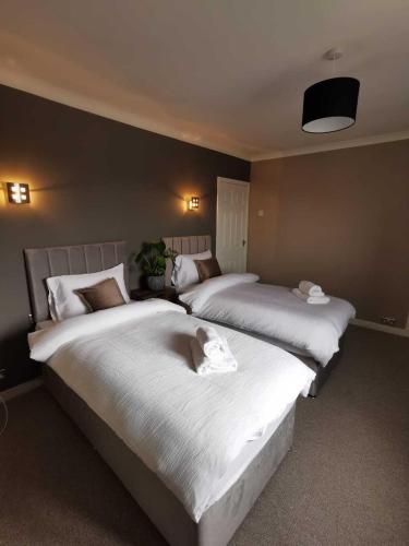 two beds sitting next to each other in a bedroom at Limekilns House in Clydebank