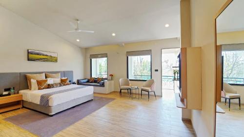 a bedroom with a bed and a living room at Palette Hotel Orient Greenz by CheckIn, Pench in Khawāsa