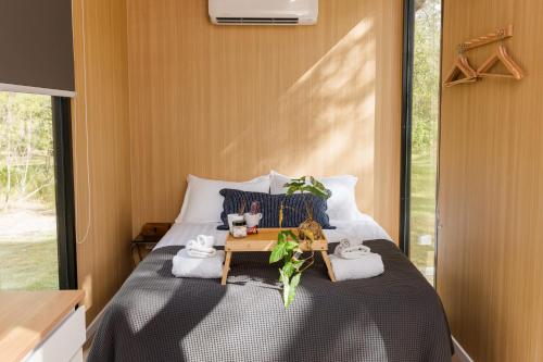 a bedroom with a bed with a table and towels at Bushwalk Escape 1770 in Agnes Water