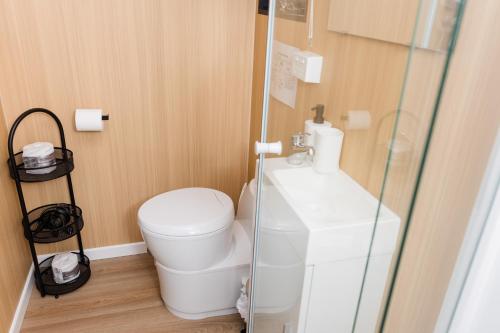 a bathroom with a toilet and a glass shower at Bushwalk Escape 1770 in Agnes Water