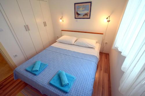 a bedroom with a bed with blue towels on it at Apartments Ravlic in Punat