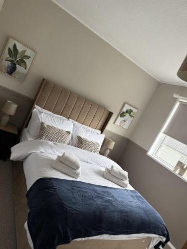 a bedroom with a large bed with two towels on it at Knowes Apartment in Duntocher