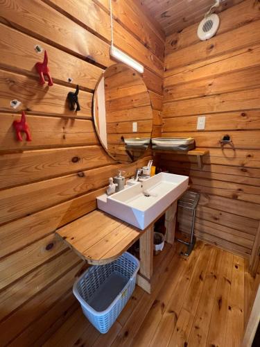 a bathroom with a sink in a wooden wall at Family Cottage Pokhara in Yamanakako
