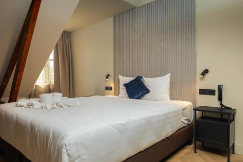 a bedroom with a large white bed and a window at Hotel Twenty-Three Amsterdam Airport in Hoofddorp