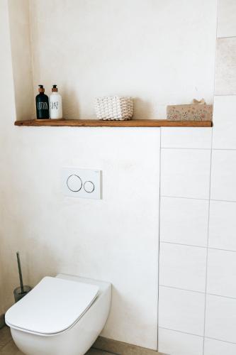 a bathroom with a white toilet and a shelf at Seetraum Steffi in Zoznegg