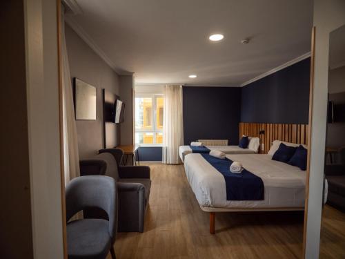 ein Hotelzimmer mit zwei Betten und einer Couch in der Unterkunft Hotel Bríos in Lugo