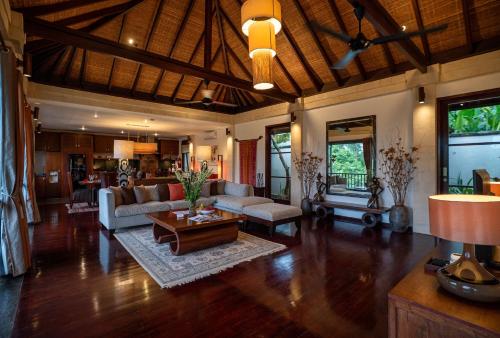 a living room with a couch and a table at Villa Ambiente by Nakula in Jimbaran