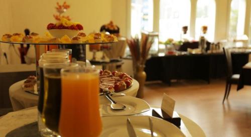 a table with a plate of food and a glass of orange juice at GHS Hotel in Brazzaville