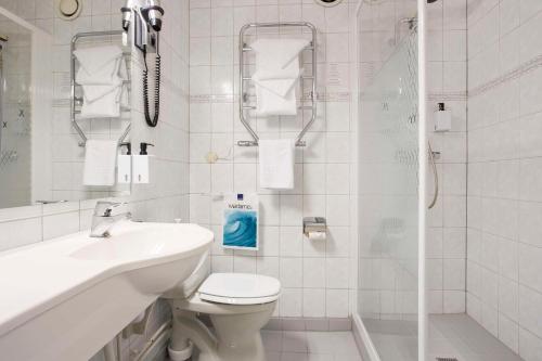 a bathroom with a toilet and a sink and a shower at Scandic Meyergården in Mo i Rana