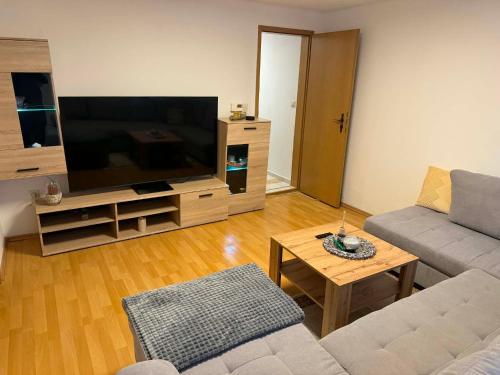a living room with a couch and a large television at Guest House Harmony in Lutherstadt Eisleben