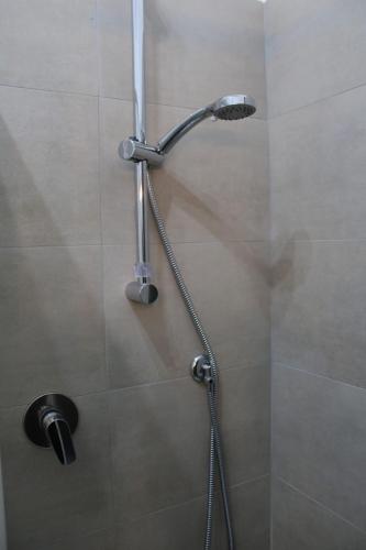 a shower with a shower head in a bathroom at La carezza dell'Elba in Poggio