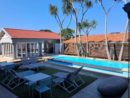 a villa with a swimming pool and palm trees at San D- Lux Boutique Hotel in Durban