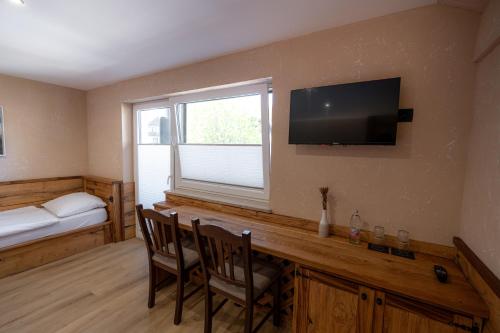 a room with a desk with two chairs and a television at Bed & Breakfast LakeBled House in Bled