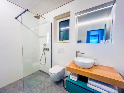 a white bathroom with a sink and a toilet at The Window in Bellinzona