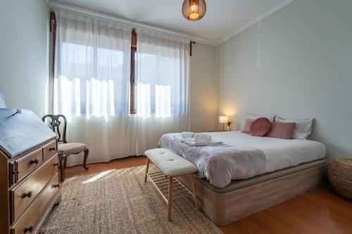 a bedroom with a bed and a dresser and a window at Patio House - 2 Bedroom flat in Porto