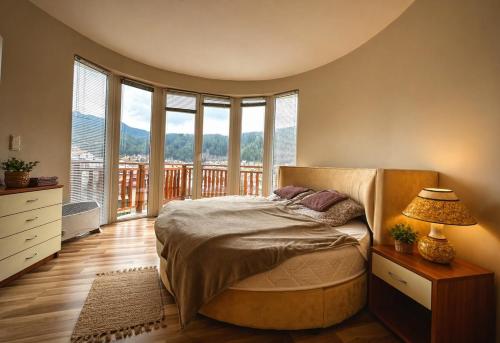 a bedroom with a bed and a large window at Panoramic Cozy Apartment in Beli Iskar