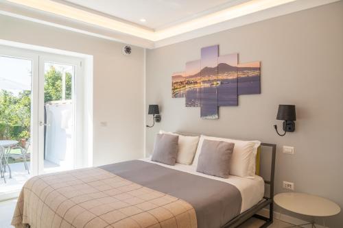 a white bedroom with a bed and a table at La Casetta di Carol in Capri