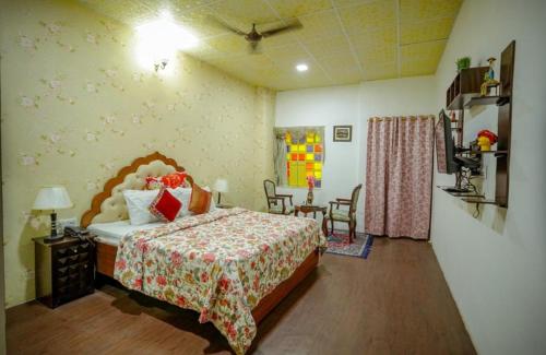 a bedroom with a bed and a table and chairs at Zero Amer Royal Farm Stay in Jaipur