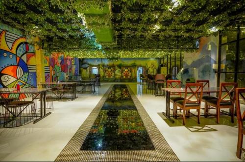 a restaurant with tables and chairs and a mural at Zero Amer Royal Farm Stay in Jaipur