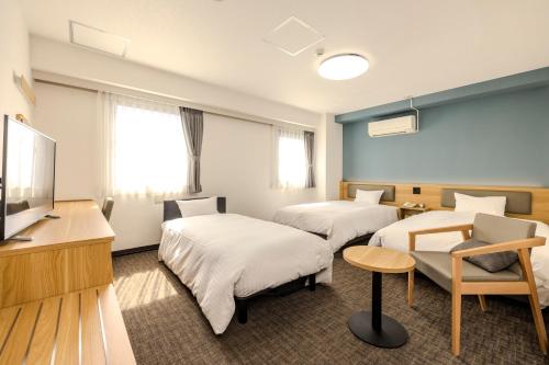 a hotel room with two beds and a flat screen tv at Kochi Sunrise Hotel in Kochi